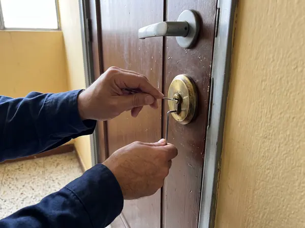 Cerrajero manipulando los pitones de un cilindro europeo con ganzúa y llave de tensión